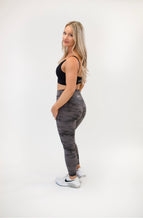 Load image into Gallery viewer, Picture of a female model with blonde hair wearing grey Napa Leggings from Roach Co, a black sports bra and white tennis shoes.