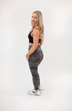 Load image into Gallery viewer, Picture of a female model with blonde hair wearing grey Napa Leggings from Roach Co, a black sports bra and white tennis shoes.
